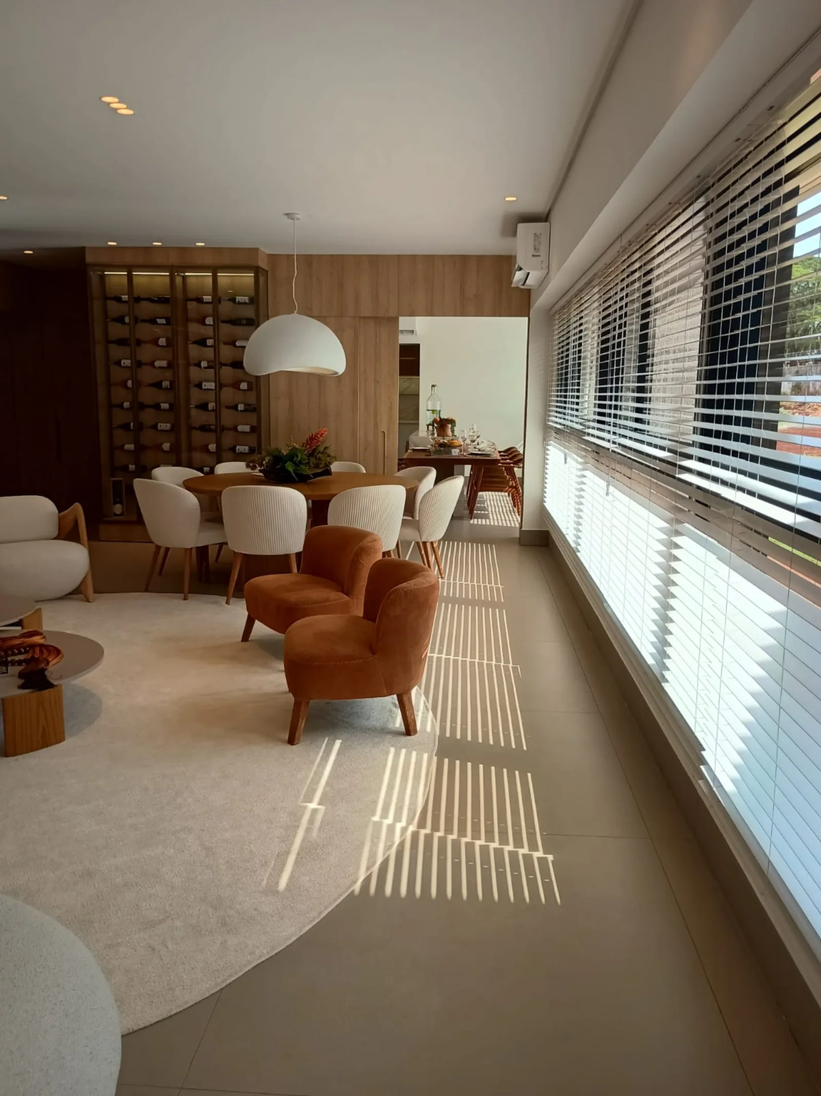 Living com vista lateral e luz natural pela persiana