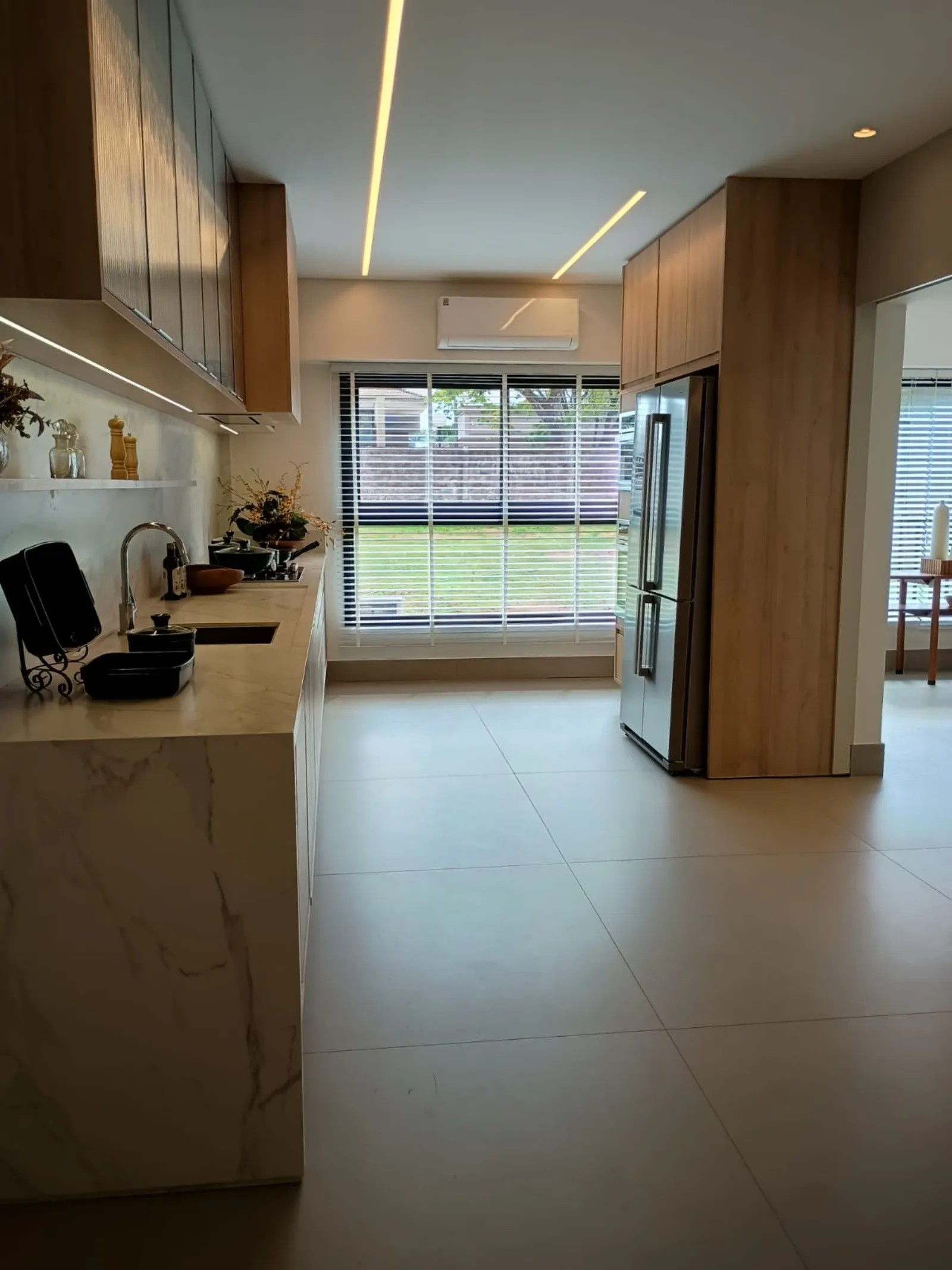 Cozinha com bancada em mármore e vista para área externa