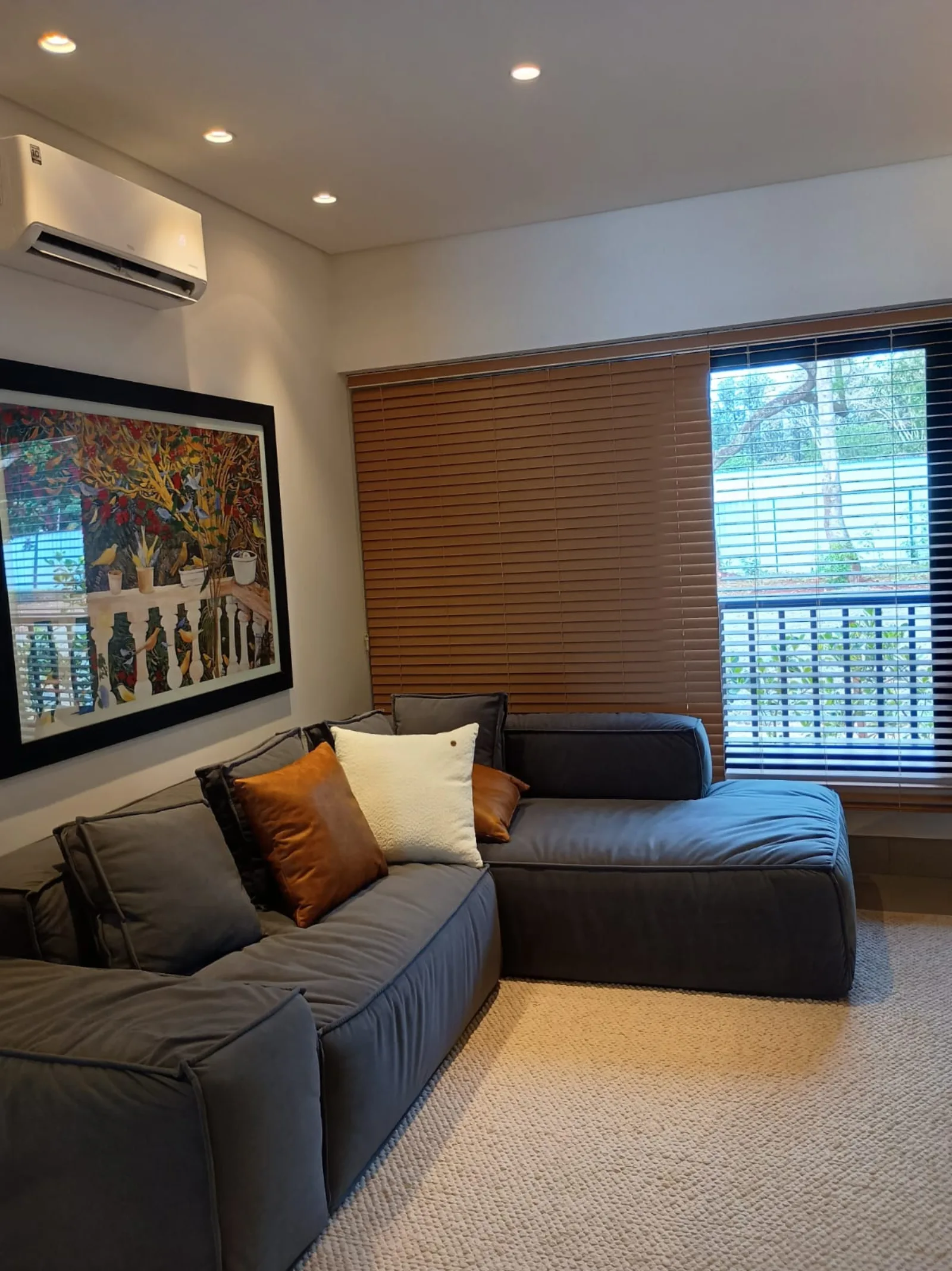 Home theater com sofá modular e obra autoral